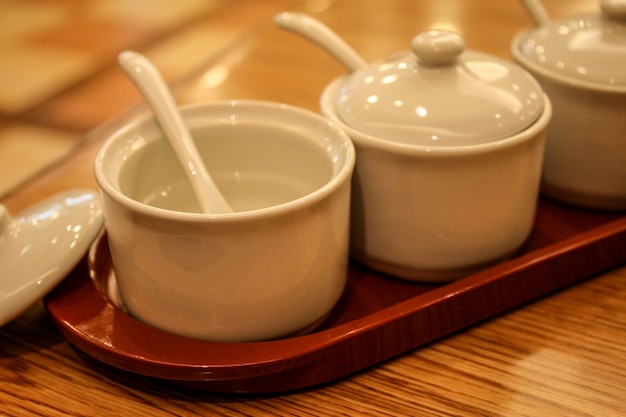 Tasse blanche vide d'ensemble en céramique de condiment