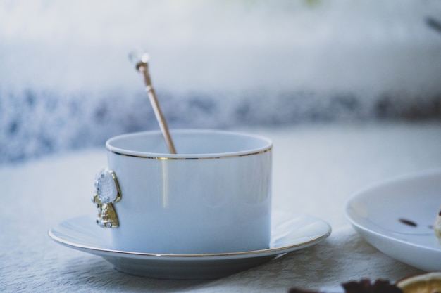 Tasse blanche vintage sur table à la lumière naturelle