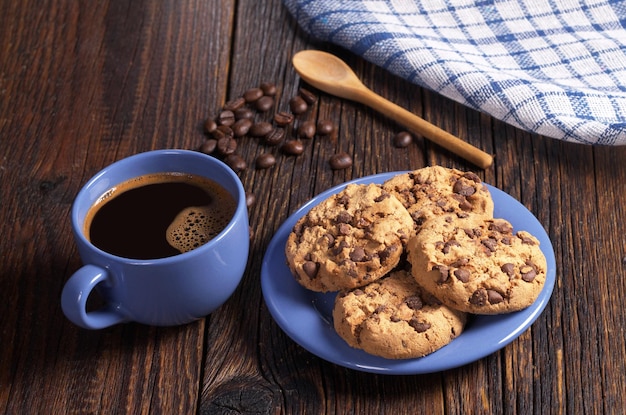 Tasse Bleue De Café Chaud Et De Biscuits Au Chocolat Pour Le Petit-déjeuner Sur Une Table En Bois Rustique