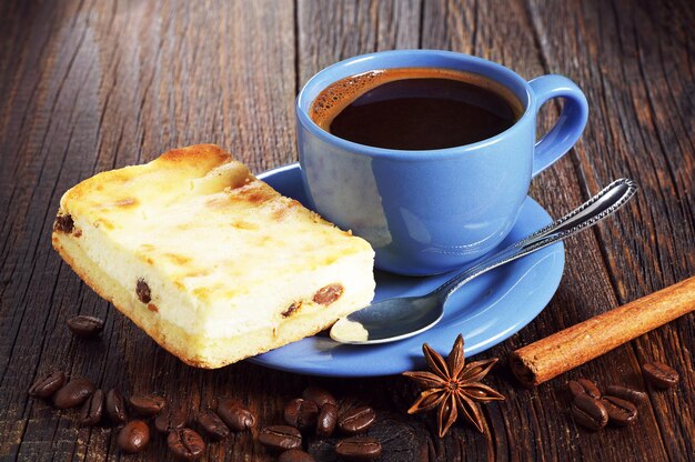 Tasse bleue de café chaud avec cheesecake sur la vieille table en bois