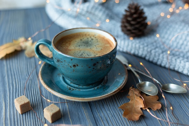 Tasse bleue avec café avec pull en tricot