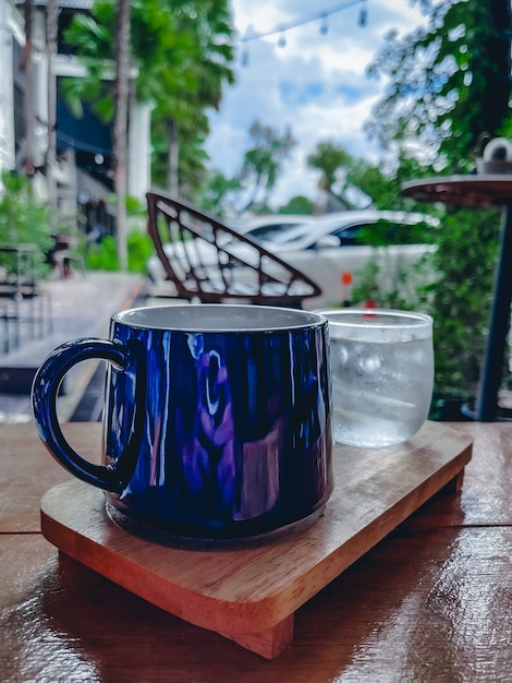 Tasse bleue sur table en bois près des parkings