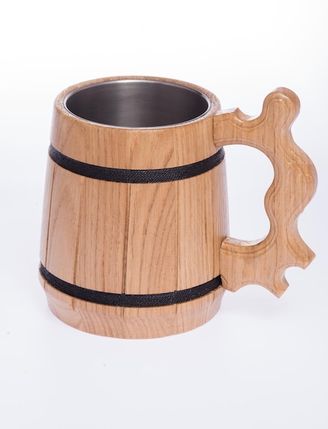 Tasse en bois pour la bière sur un fond blanc neutre.