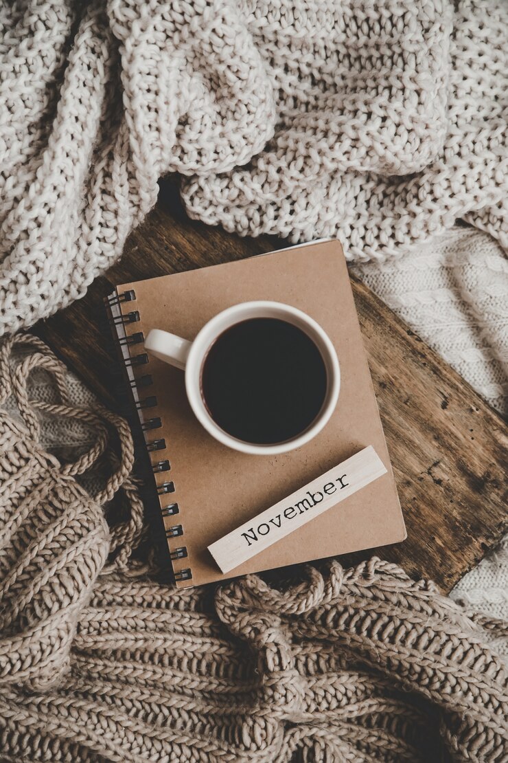 Photo tasse de boisson chaude sur le cahier et les vêtements à tricoter