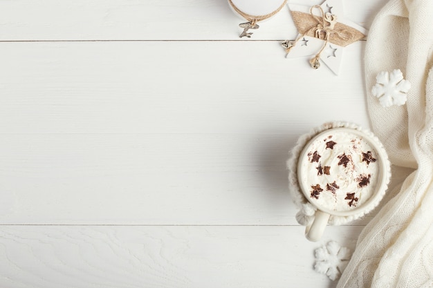 Une tasse de boisson chaude en hiver avec de la crème fouettée et de la poudre à saupoudrer