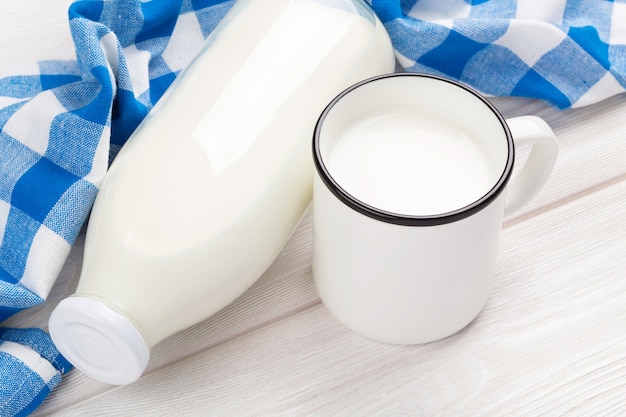 Tasse et bouteille de lait sur la table en bois