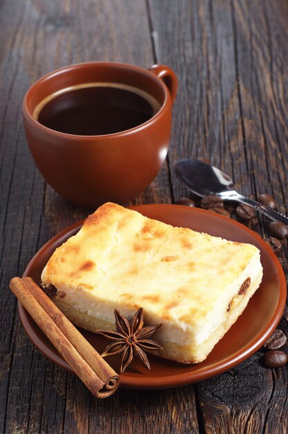 Tasse brune de café chaud avec cheesecake sur une table en bois foncé