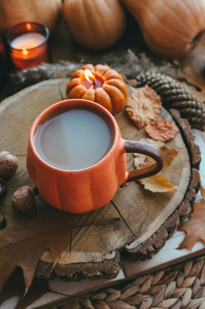 Une tasse de cacao et une bougie allumée et un décor d'automne sur le rebord de la fenêtre