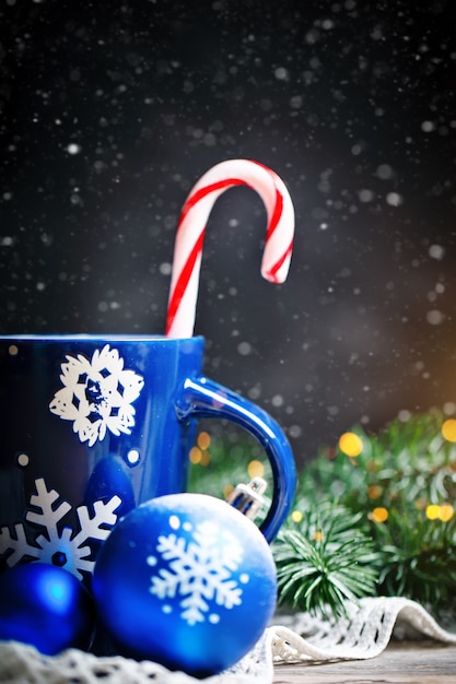 Tasse de cacao, cadeaux et branches de sapin sur une table en bois.