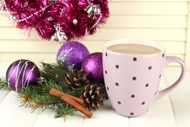 Tasse de cacao chaud avec bosses et décorations de Noël sur table sur fond de bois