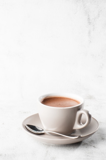 Tasse de cacao chaud ou chocolat chaud ou americano dans une tasse blanche isolée sur fond de marbre brillant. Vue aérienne, espace copie. Publicité pour le menu du café. Menu du café. Photo verticale. traditionnel