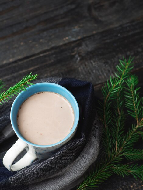 Tasse de cacao chaud sur une table en bois avec des branches du sapin de Noël