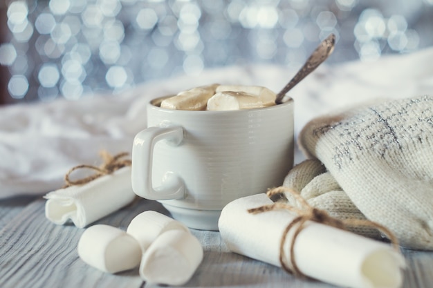 Une tasse de cacao et de guimauve dans le cadre de la table de Noël du Nouvel An sur un fond brillant