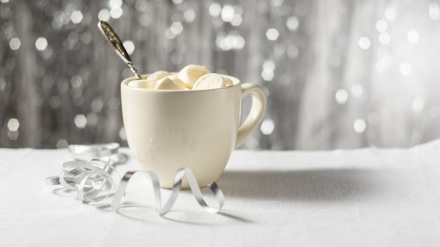 Photo une tasse de cacao et de guimauve dans le cadre de la table de noël du nouvel an sur un fond brillant