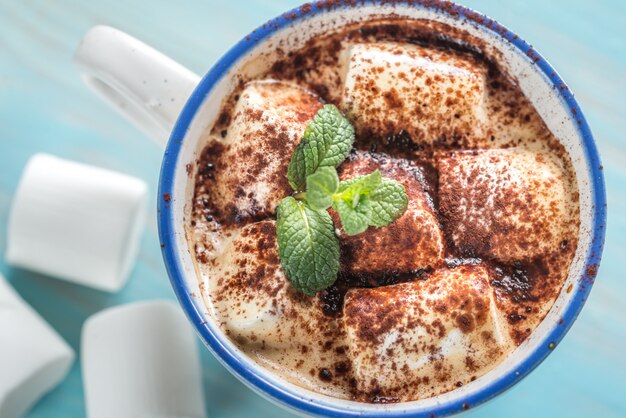 Tasse de cacao avec des guimauves et de la poudre de cacao