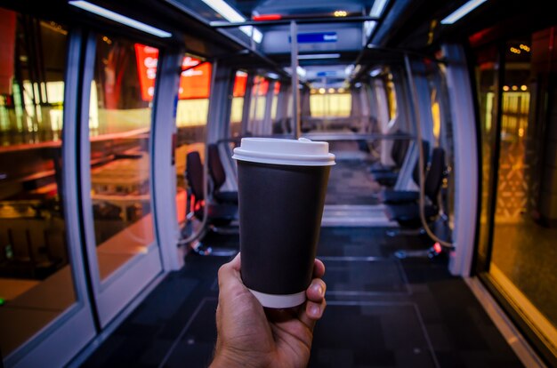 Tasse de café à l'aéroport Mans main avec tasse noire