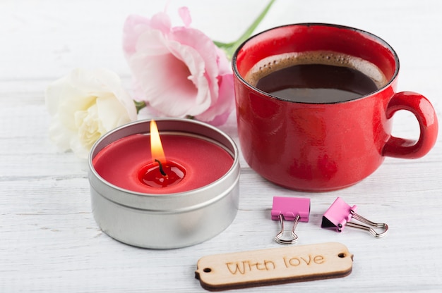 Tasse de café, allumé bougie rouge, fleurs