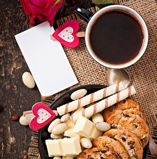 Une tasse de café avec des amandes de chocolat blanc et des biscuits