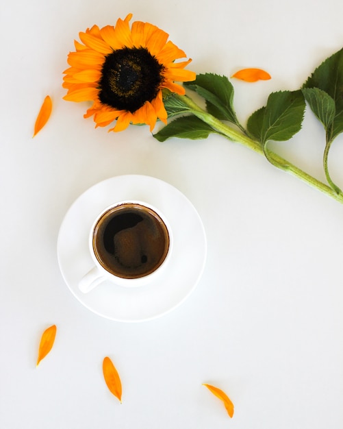 Tasse de café americano ou expresso frais avec des mots de fleur et de motivation encadrent sur fond de tableau blanc.