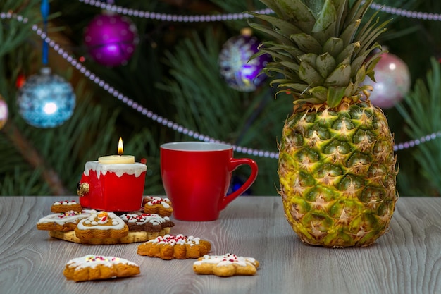 Tasse de café d'ananas et un sapin avec des ornements de Noël sur le fond