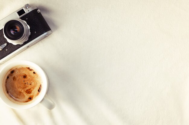 Tasse de café appareil photo et smartphone sur une couverture douce