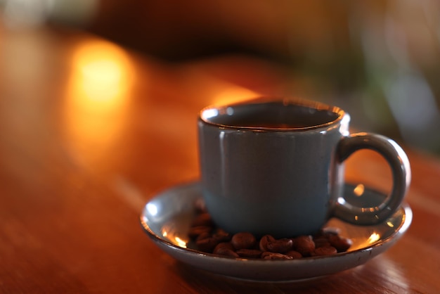 Tasse de café aromatique chaud et de grains torréfiés sur une table en bois au café Espace pour le texte