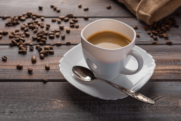 Tasse de café aromatique avec une cuillère sur une serviette en lin grains de café et sac