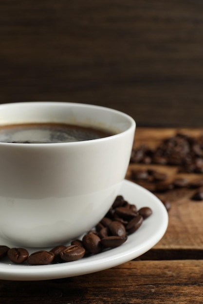 Tasse de café aromatique et de haricots sur une table en bois agrandi Espace pour le texte