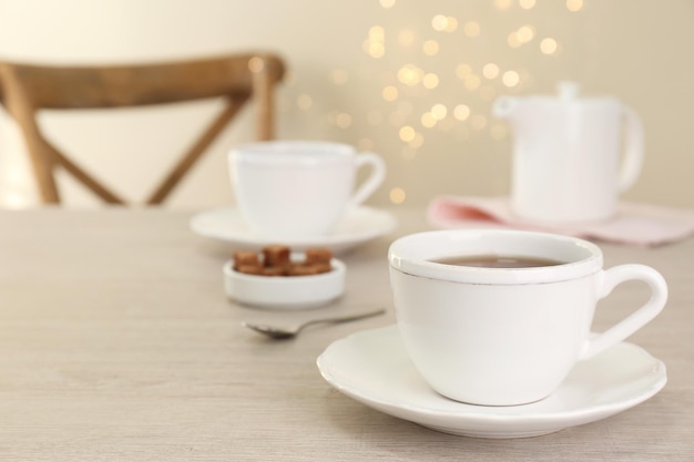 Tasse de café aromatique sur une table en bois blanche à l'intérieur de l'espace pour le texte Effet bokeh