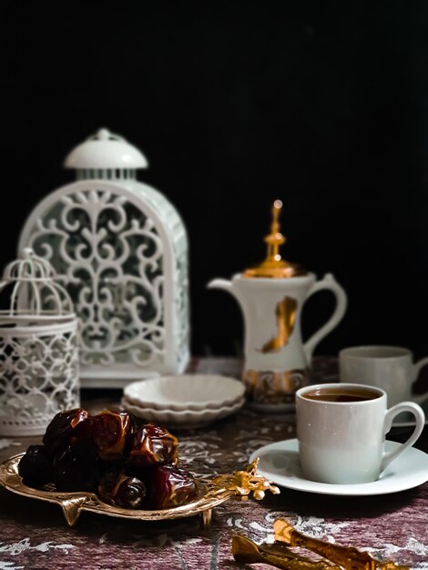 Une tasse de café et une assiette de nourriture avec une lanterne blanche en arrière-plan.