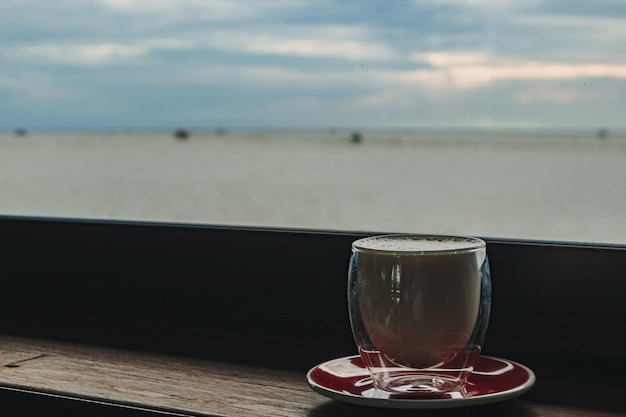 Tasse de café au bar avec vue sur la mer en soirée