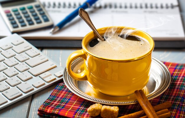 Une tasse de café au bureau avec des articles pour faire des affaires.