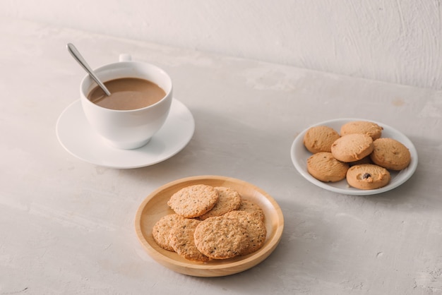 Tasse de café au lait ou cappuccino avec biscuits sur fond de pierre clair