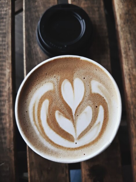 Une tasse de café au lait chaud, cappuccino ou expresso avec mousse de lait sur une table rustique