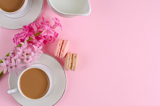 Tasse de café au lait, macarons, pot de lait rose pastel