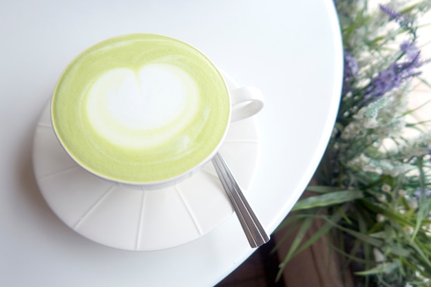 Tasse de café au lait matcha vert sur table blanche. Vue de dessus