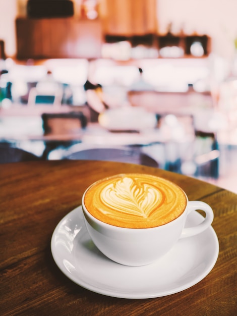 Tasse de café au lait sur la table en bois au café.