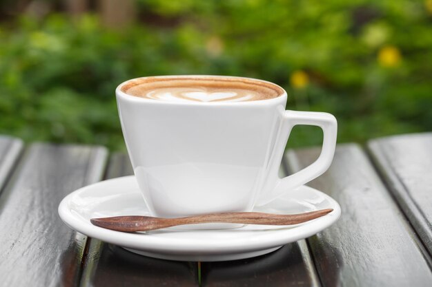 Une tasse de café au lait sur une table en bois