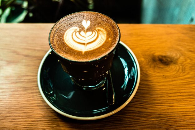 Une tasse de café au lait vue de dessus avec de la mousse en forme de feuille