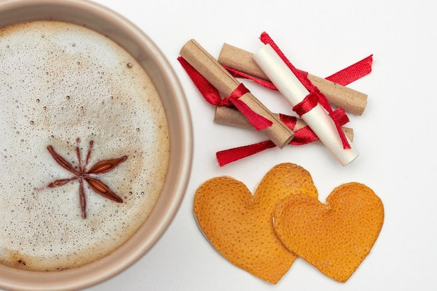 Tasse de café aux épices notes romantiques avec souhaits et deux coeurs à base d'écorces d'orange séchées