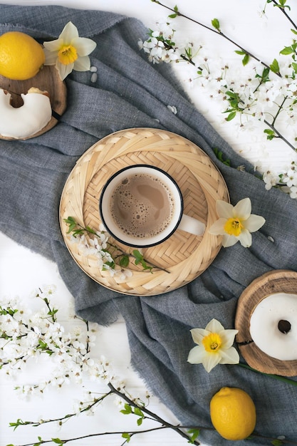 Une tasse de café avec un beignet sur une table