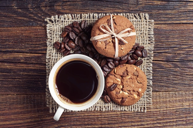 Tasse à café et biscuits au chocolat pour le petit-déjeuner sur une table rustique, vue de dessus