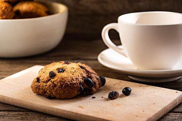 Une tasse de café et des biscuits à l'avoine sur la table de la cuisine.