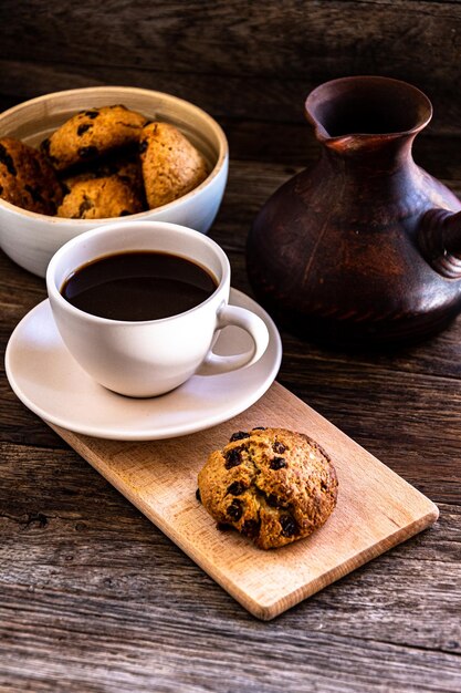 Une tasse de café et des biscuits à l'avoine sur la table de la cuisine.