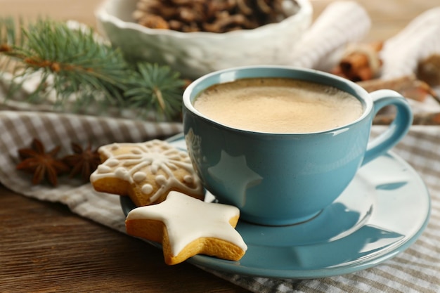 Tasse de café avec des biscuits en forme d'étoile et une branche d'arbre de Noël sur une serviette