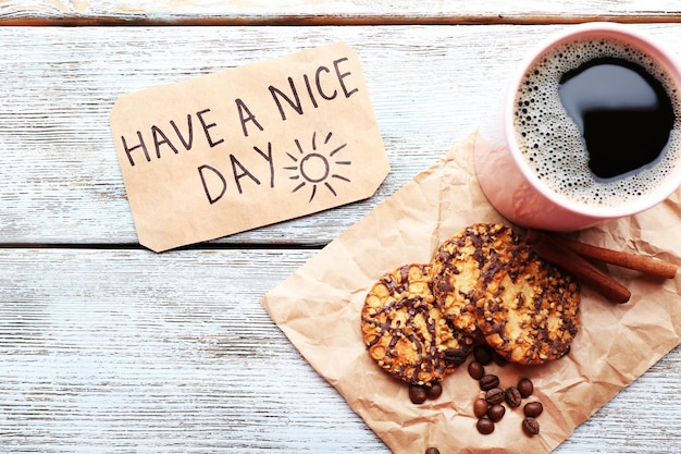 Tasse de café avec des biscuits frais et massage Have A Nice Day sur la vue de dessus de table en bois