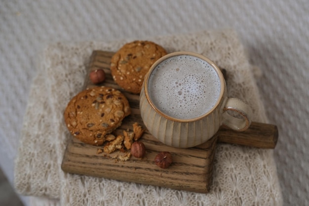 Une tasse de café et des biscuits sur un plateau sur le lit Composition confortable d'automne Hygge style de vie ambiance chaleureuse