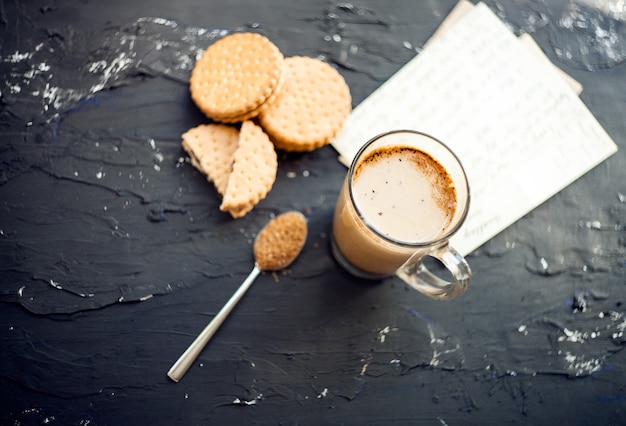 Photo tasse de café avec biscuits et shugar bruntasse de latte fraîchement infusée servie avec du chocolat