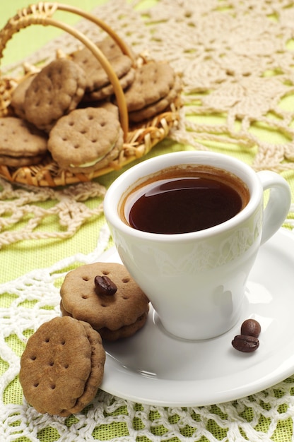 Tasse de café et de biscuits sucrés sur une nappe
