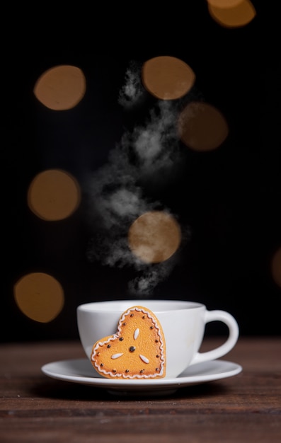 Tasse de café et biscuits sur une table avec guirlande lumineuse